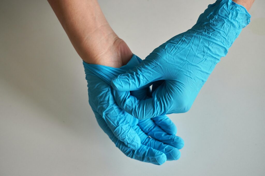 Close-up of hands wearing blue disposable gloves, illustrating safety and hygiene.